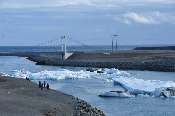 Blocos de gelo passam sob a ponte no seu caminho para o mar, no Parque de Skaftafell, no sul da Islândia